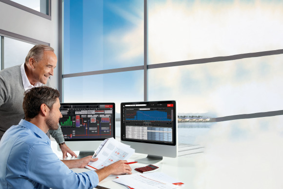 2 Männer vor PC-Bildschirmen bei der Überwachung des Heizhauses